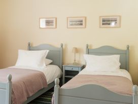 A bedroom with two beds and a nightstand at Sandridge Barton Stoke Gabriel