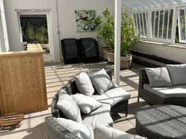 A conservatory with seating and plants at Wootton House Butleigh Wootton near Compton Dundon