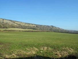 A field with grass and hills under a clear sky at The Barn in Compton Bishop, near Cheddar