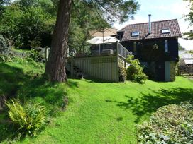 A building with a deck and stairs in a garden at Little Evanses, Dalwood, near Axminster