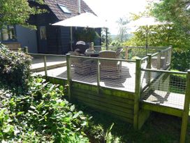A deck with chairs and a table at Little Evanses Dalwood, near Axminster