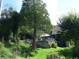 A house with a deck and trees in an outdoor area at Little Evanses, Dalwood, near Axminster