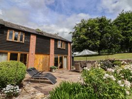 An outdoor area with a building and seating at The Old Log Shed in Honiton