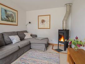 A living room with a fireplace and a sofa at The Old Log Shed in Honiton
