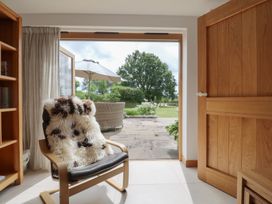 A snug with doors opening to the garden at The Old Log Shed in Honiton