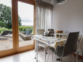 A dining room with a table set for tea at The Old Log Shed in Honiton