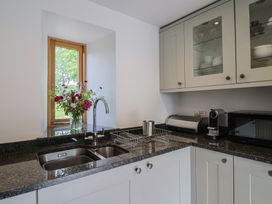 A kitchen with a sink and microwave at The Old Log Shed in Honiton
