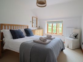 A bedroom with a bed and dresser at The Old Log Shed in Honiton