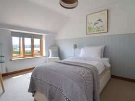 A bedroom with a bed and a window at The Old Log Shed in Honiton