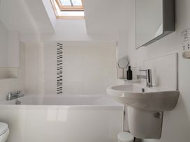 A bathroom with a bathtub, toilet, and sink at The Old Log Shed in Honiton