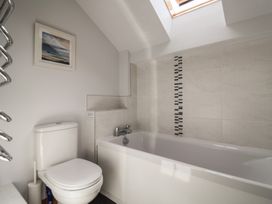 A bathroom with a bathtub and toilet at The Old Log Shed in Honiton