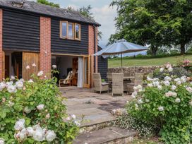 A patio with table and chairs at The Old Log Shed in Honiton