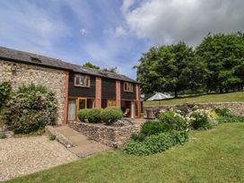 An outdoor area with a garden and seating at The Old Log Shed in Honiton