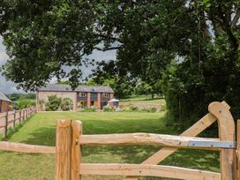 An outdoor area with a house in the background at The Old Log Shed in Honiton