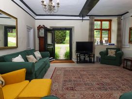 A living room with a television and mirror at Hornshayne Farmhouse, Farway, near Honiton