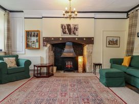 A living room with a fireplace and two sofas at Hornshayne Farmhouse in Farway, near Honiton