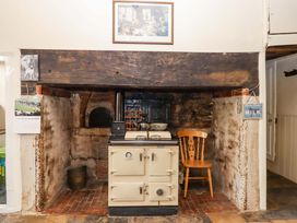 A kitchen with a range cooker and a stool at Hornshayne Farmhouse, Farway, near Honiton