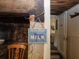 A sign that reads Farm Fresh Milk with a wooden chair at Hornshayne Farmhouse near Honiton