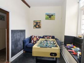 A foosball table and a sofa in a game room at Hornshayne Farmhouse, Farway, near Honiton