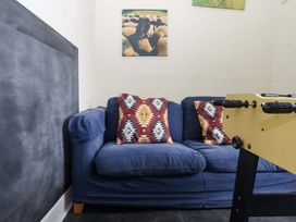 A sofa with cushions and a foosball table in the game room at Hornshayne Farmhouse, Farway, near Honiton