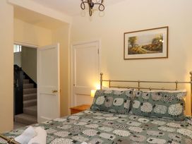 A bedroom with a bed and staircase at Hornshayne Farmhouse, Farway, near Honiton