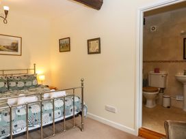 A bedroom with a bed and adjoining bathroom at Hornshayne Farmhouse, Farway, near Honiton