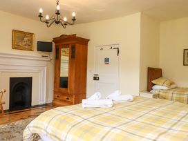 A bedroom with two beds and a wardrobe at Hornshayne Farmhouse Farway, near Honiton