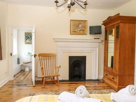 A bedroom with a rocking chair and wardrobe at Hornshayne Farmhouse in Farway, near Honiton