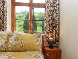 A bedroom with a bed and a window overlooking green fields at Hornshayne Farmhouse, Farway, near Honiton