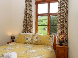A bedroom with a bed and window at Hornshayne Farmhouse, Farway, near Honiton