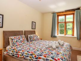 A bedroom with a bed and window at Hornshayne Farmhouse near Honiton