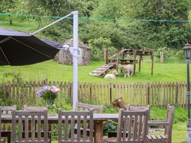 A garden with sheep and a table and chairs at Hornshayne Farmhouse near Honiton