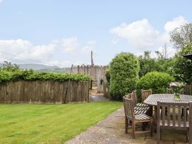 A garden with a wooden table and chairs at Hornshayne Farmhouse in Farway, near Honiton