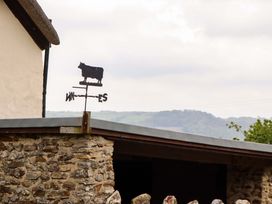 A weather vane in the shape of a cow on a building at Hornshayne Farmhouse Farway, near Honiton