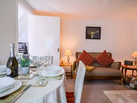 A living room with a dining table and couch at Poppy Cottage in Charlton Marshall