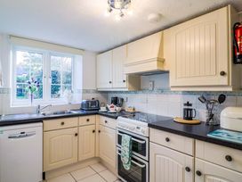 A kitchen with cabinets and appliances at Poppy Cottage Charlton Marshall