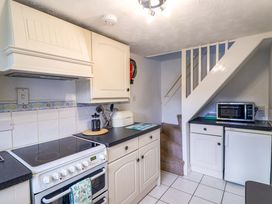 A kitchen with a stove and microwave at Poppy Cottage in Charlton Marshall