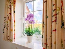 A window with a flowerpot at Poppy Cottage in Charlton Marshall