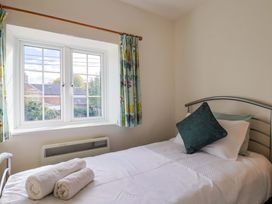 A bedroom with a bed and window at Poppy Cottage in Charlton Marshall