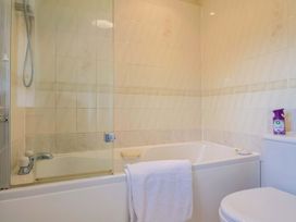 A bathroom with a bath tub and shower at Poppy Cottage in Charlton Marshall