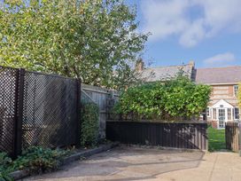 A garden with a tree and a wooden fence at Poppy Cottage Charlton Marshall