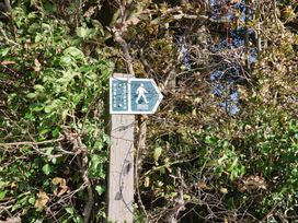 A footpath sign on a wooden post surrounded by bushes at Poppy Cottage Charlton Marshall