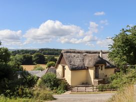A thatched cottage with a garden and steps at The Cottage in Sampford Courtenay
