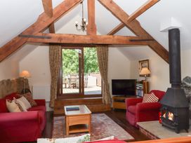 A living room with a television and a stove at The Cottage in Sampford Courtenay