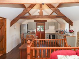 A kitchen with a dining area and appliances at The Cottage in Sampford Courtenay