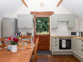 A kitchen with a table and chairs at The Cottage in Sampford Courtenay