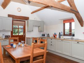 A kitchen with a table and chairs at The Cottage in Sampford Courtenay