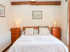 A bedroom with a bed and nightstands at The Cottage in Sampford Courtenay