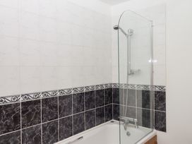 A bathroom with a bathtub and shower at The Cottage in Sampford Courtenay