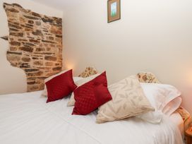 A bedroom with a bed and decorative pillows at The Cottage in Sampford Courtenay